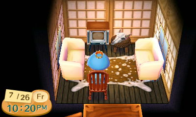 Cream sofas and a cowhide rug in Animal Crossing.