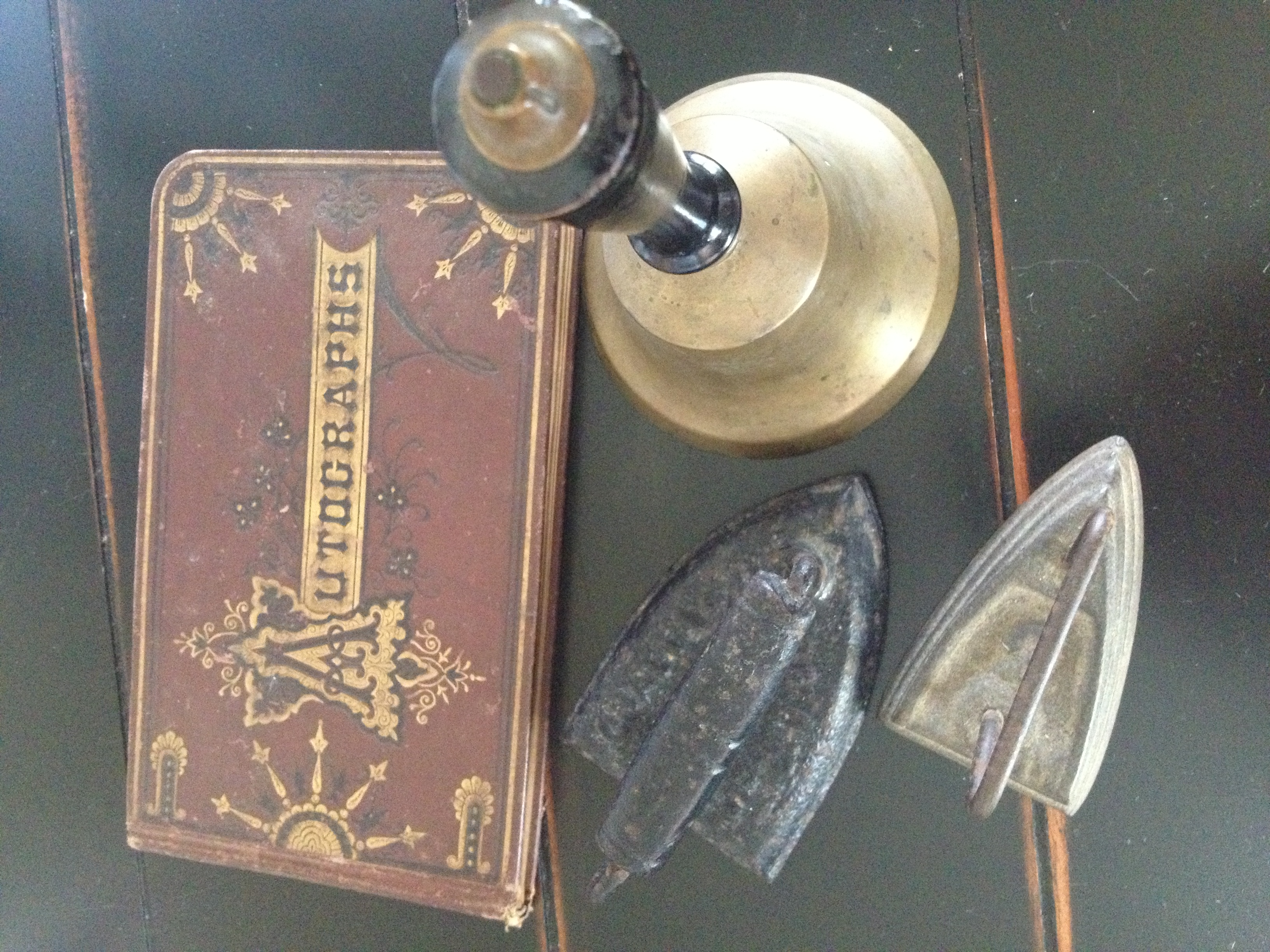 Antiques: an autograph book, a bell, and two irons.