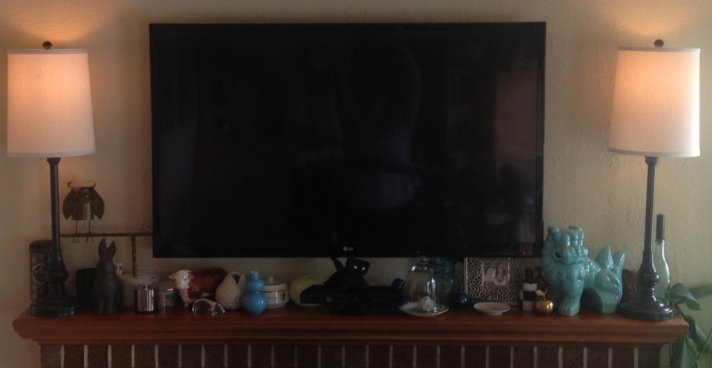 A picture of my TV, styled in with antiques and other decorative objects.